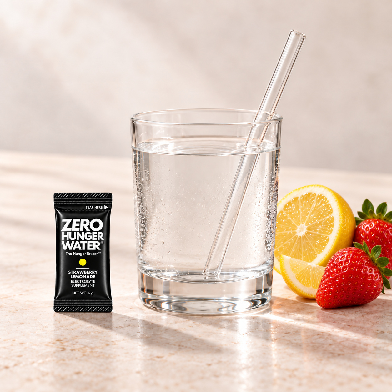 Strawberry Lemonade stick beside a glass of water with a straw