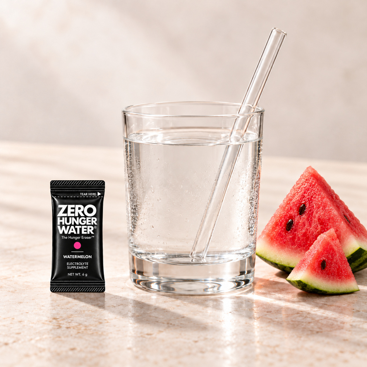 Watermelon stick beside a glass of water with a straw