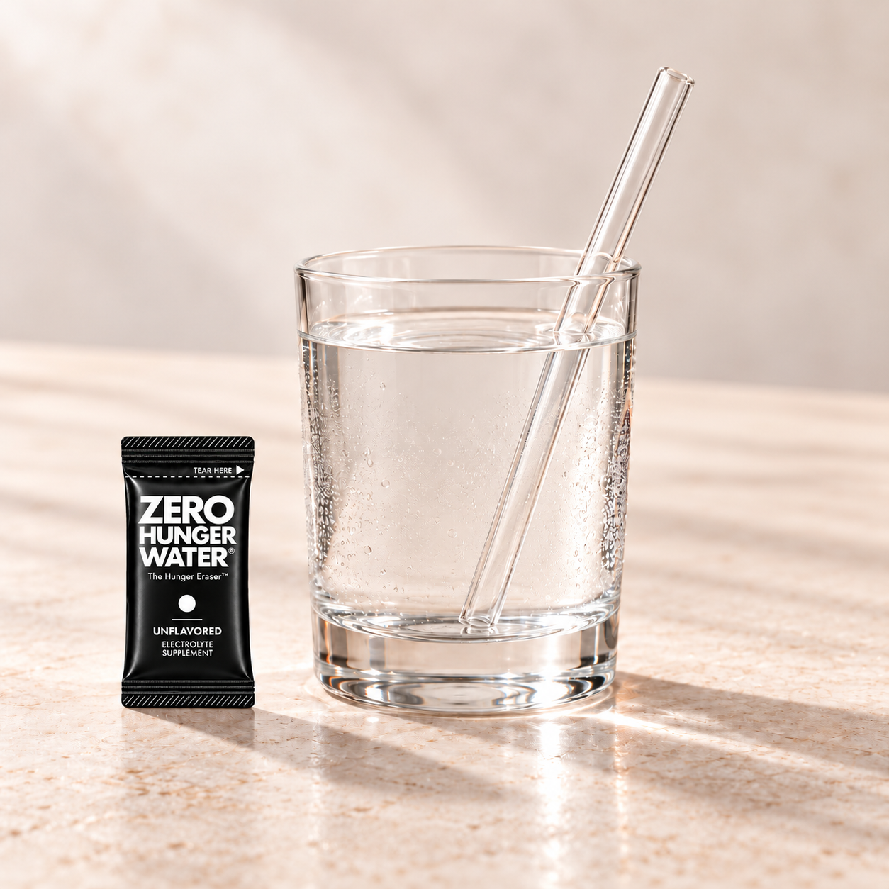 Unflavored stick beside a glass of water with a straw