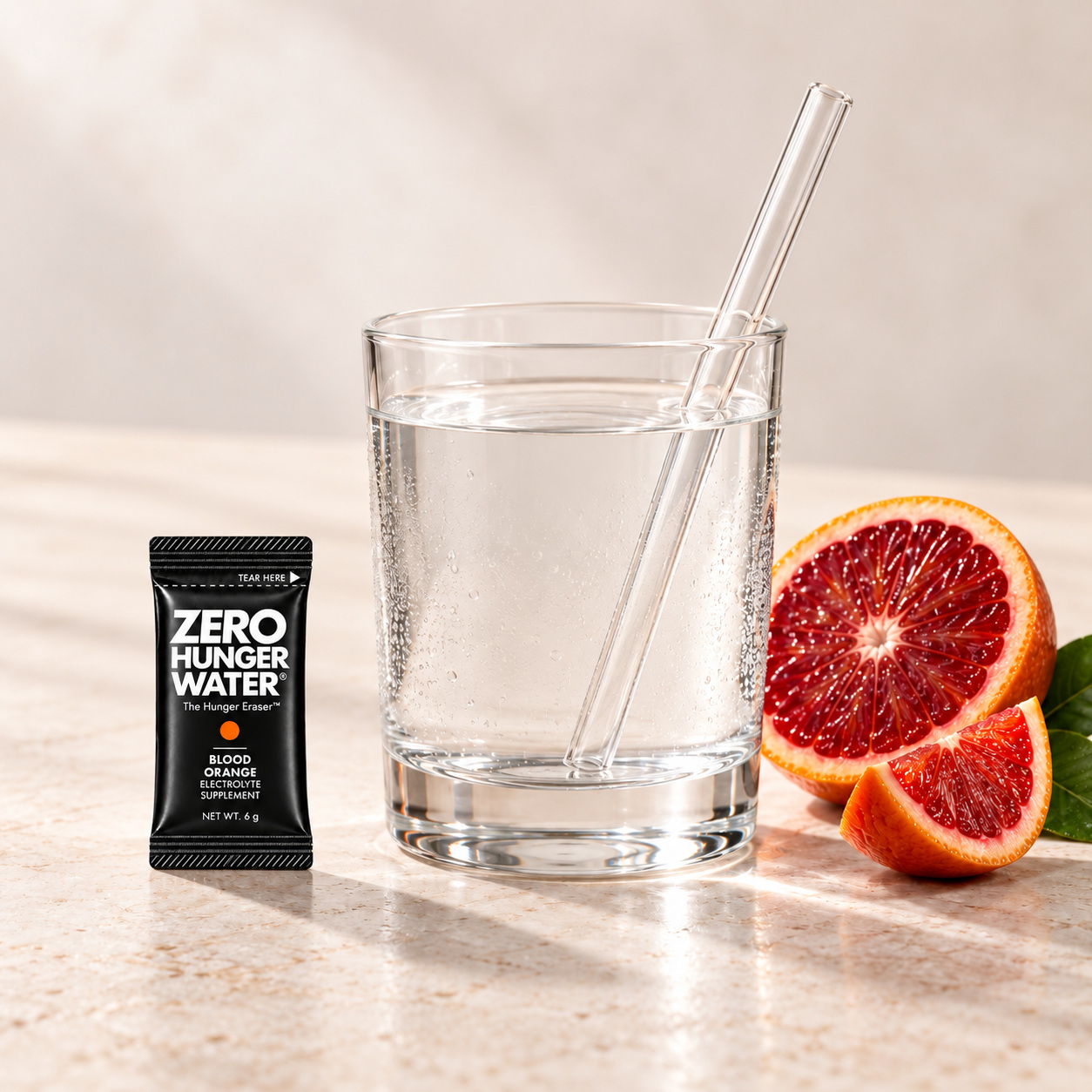 Blood Orange stick beside a glass of water with a straw
